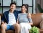 Asian heterosexual couple sitting happily on a couch
