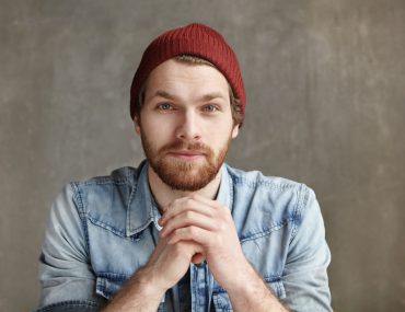 Good-looking young European wearing stylish hat and blue jeans shirt