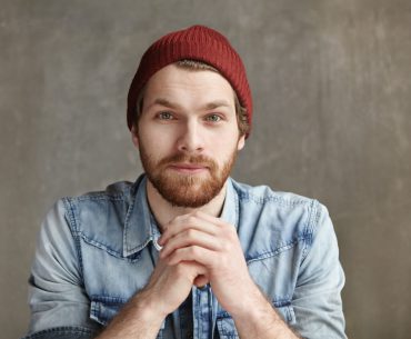 Good-looking young European wearing stylish hat and blue jeans shirt