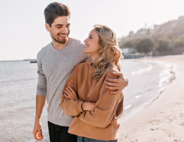 Young couple walking by the beach