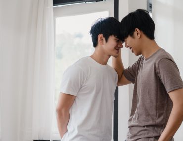 Asian gay couple standing by the mirror
