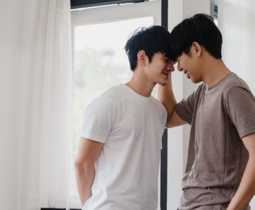 Asian gay couple standing by the mirror