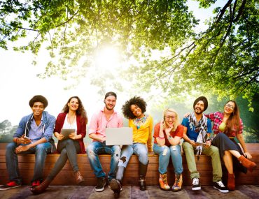 College students siting under a tree