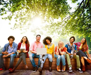 College students siting under a tree