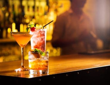 Three cocktail glasses on a bar table