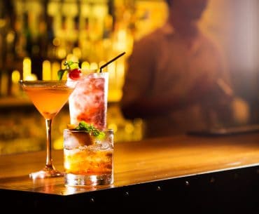 Three cocktail glasses on a bar table