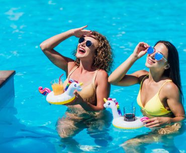 Two beautiful girls in swimsuits in the pool