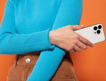 Woman wearing blue sweatshirt holding an iPhone