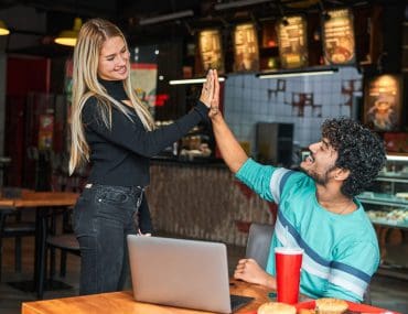 Girl giving high-five to a guy in a bar
