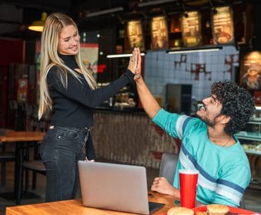 Girl giving high-five to a guy in a bar
