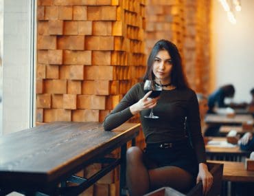 Elegant woman on red lipstick having a drink at the bank
