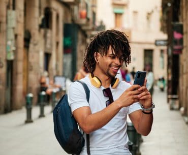 Eugene Hookup | Where to Pick Up and Date Girls in Eugene black man with dreadlocks holding up his phone in the middle of the street