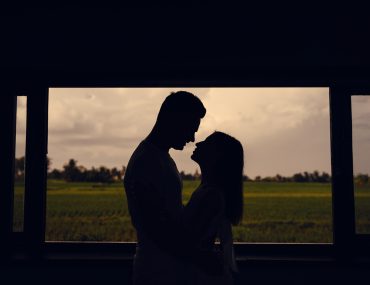 Silhouette of local hookup couple on sunset background
