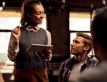 Waitress taking orders from a man in a restaurant
