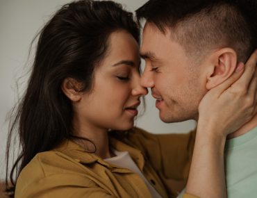 Woman leaning in to kiss a man