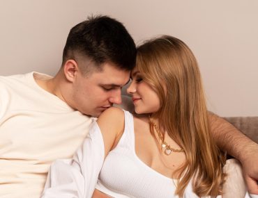 Man kissing woman's shoulders