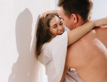 Man pinning a woman to the wall passionately