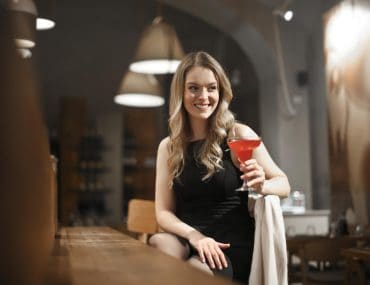 Young woman having a cocktail drink at a bar