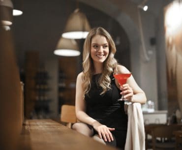 Young woman having a cocktail drink at a bar