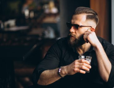 Bearded man having a drink in a bar