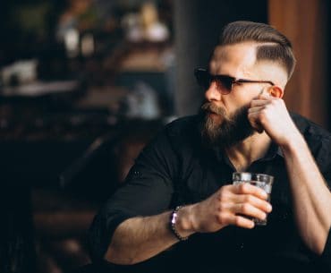 Bearded man having a drink in a bar
