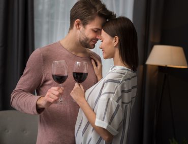 A couple holding a glass of wine having a romantic moment