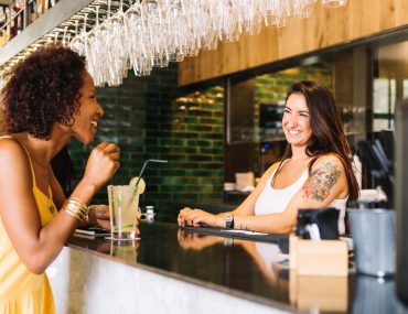 Young woman talking to a female bartender