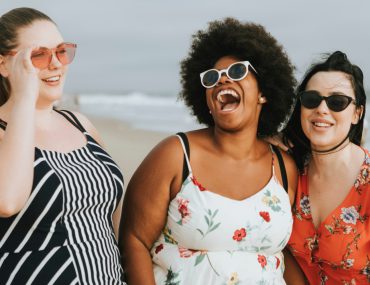 Plus size women laughing on the beach