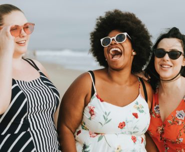 Plus size women laughing on the beach