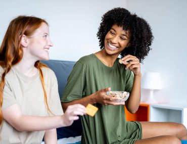 Couple of gay woman having breakfast together at bed