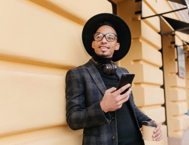 The Best Adult Hookup Applications for Android Users Young man wearing stylish black suit using his android phone