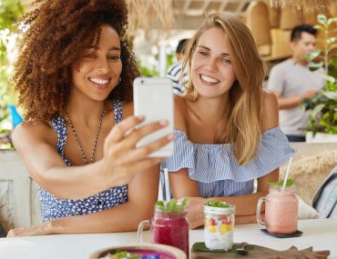 Female friends enjoying drinks in a cozy terrace bar