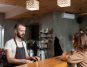 bartender in apron serving coffee to a young woman