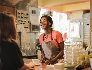 Female bartender attending to a customer at the counter
