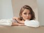 Woman wearing white resting her arms on a couch